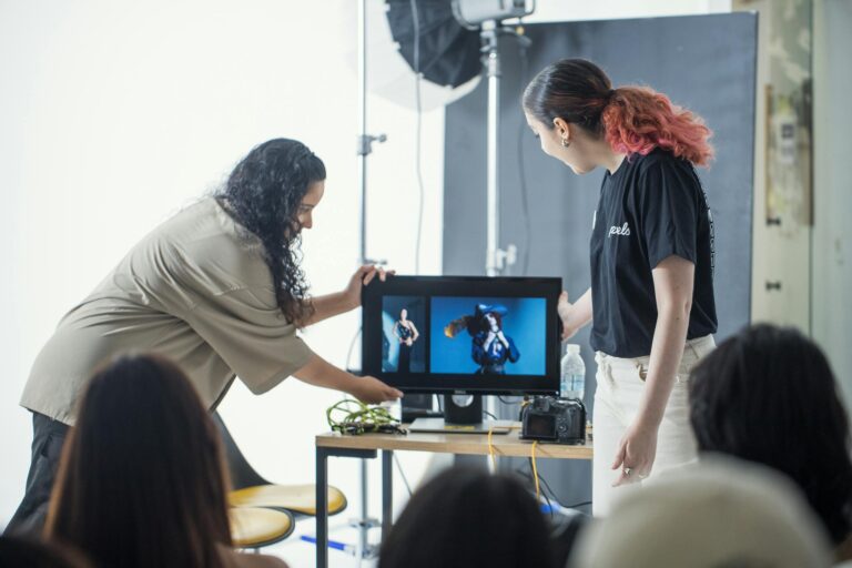 Photographers reviewing images on a monitor during a studio workshop.